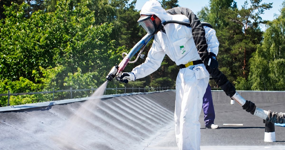 Technician spray-applying polyurea roof coating